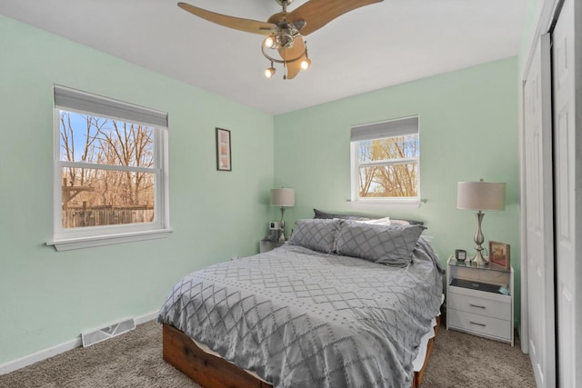 bedroom with carpet flooring, a closet, a ceiling fan, visible vents, and baseboards
