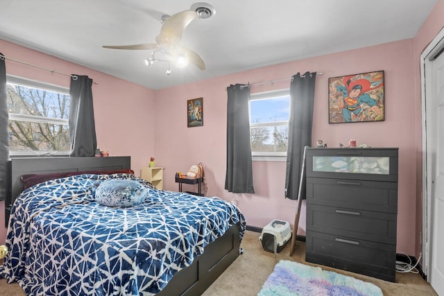 carpeted bedroom with baseboards, ceiling fan, and multiple windows