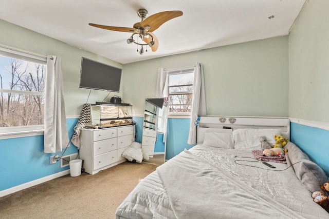 carpeted bedroom with ceiling fan and baseboards