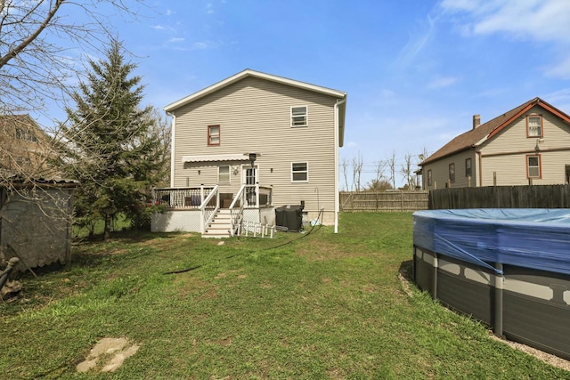 rear view of house with a fenced in pool, a lawn, a wooden deck, and a fenced backyard