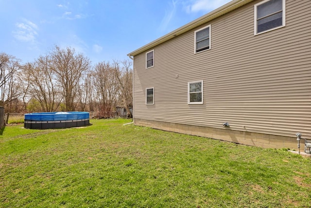 view of home's exterior featuring a covered pool and a lawn
