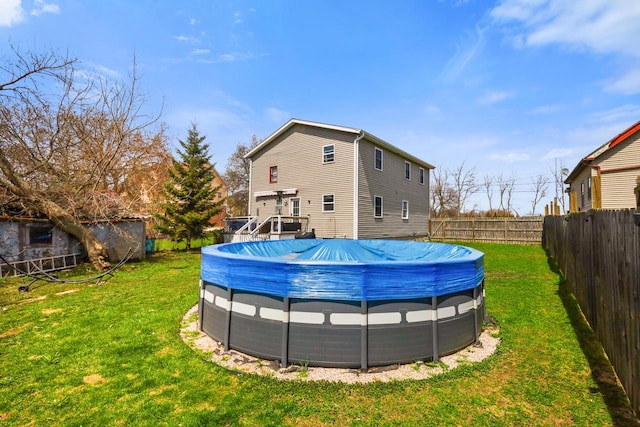 back of house featuring a yard, a fenced in pool, and a fenced backyard