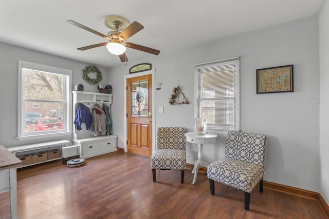 sitting room with ceiling fan, a wealth of natural light, wood finished floors, and baseboards