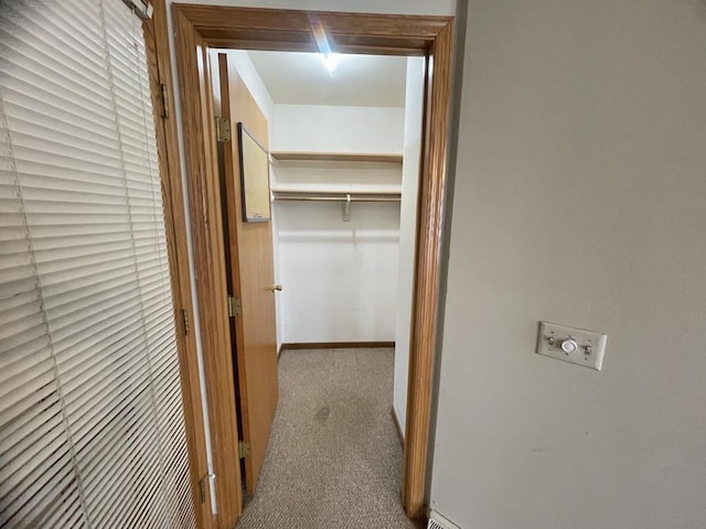 corridor with carpet flooring and baseboards