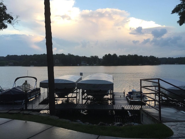 dock area featuring a water view, a forest view, and boat lift