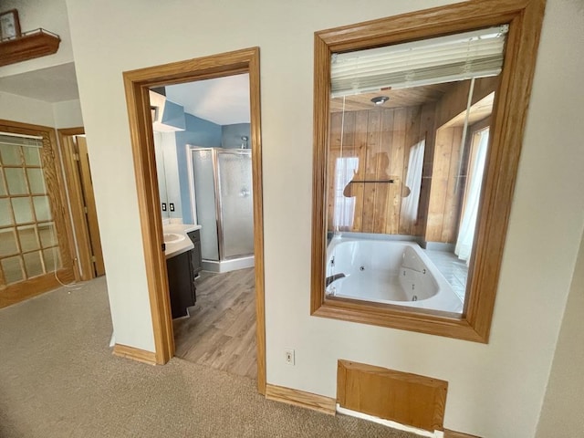 full bath featuring a whirlpool tub, a shower stall, vanity, and baseboards