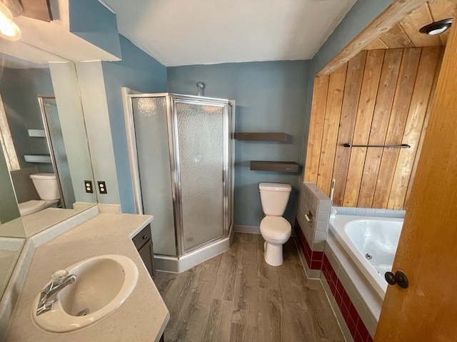 full bath featuring toilet, vanity, a shower stall, and wood finished floors