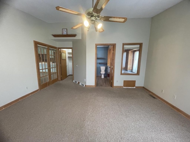 carpeted empty room with baseboards, visible vents, ceiling fan, and french doors