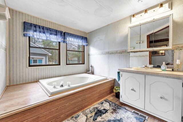 11689 Eagle Bluff Ln, Crivitz, WI 54114 - full bathroom with vanity, a bath, visible vents, wallpapered walls, and wood finished floors