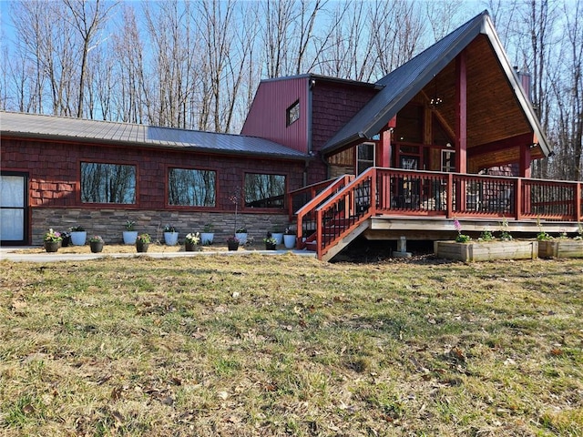 546 315th St, Knapp, WI 54749 - rear view of property with stone siding, a deck, a yard, and metal roof