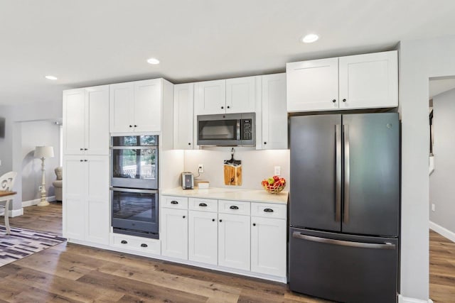 911 Fawn Ct, Wisconsin Dells, WI 53965 - kitchen with stainless steel appliances, white cabinets, wood finished floors, light countertops, and recessed lighting