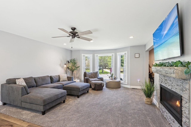 911 Fawn Ct, Wisconsin Dells, WI 53965 - carpeted living area with a stone fireplace, a ceiling fan, recessed lighting, and baseboards