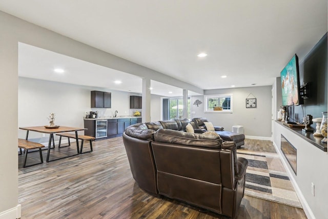 911 Fawn Ct, Wisconsin Dells, WI 53965 - living room with wine cooler, bar with sink, dark wood-style floors, recessed lighting, and baseboards
