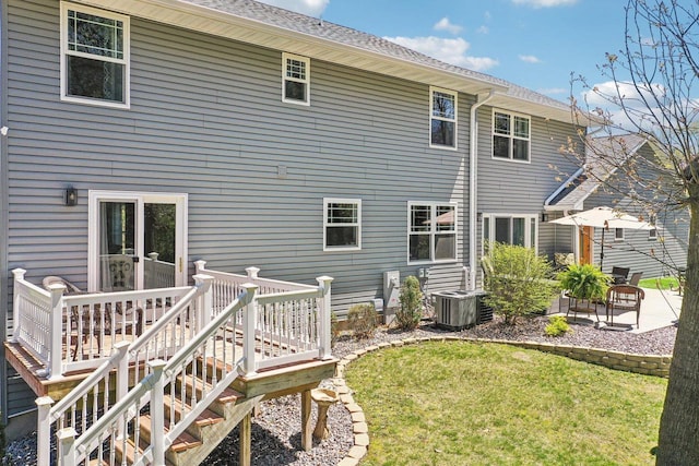 911 Fawn Ct, Wisconsin Dells, WI 53965 - rear view of house featuring central AC unit, a lawn, a deck, and a patio area