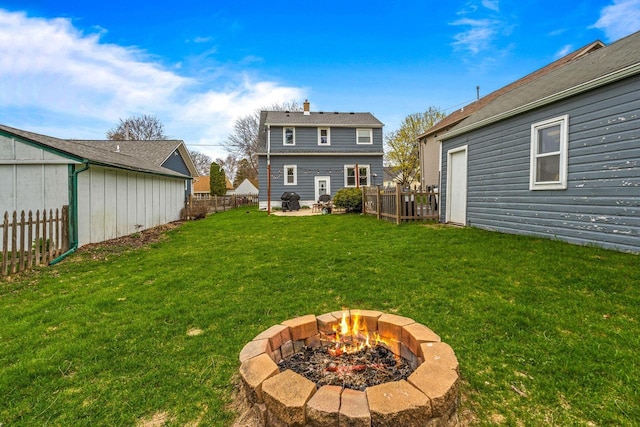 view of yard with a fire pit, a fenced backyard, and a patio area