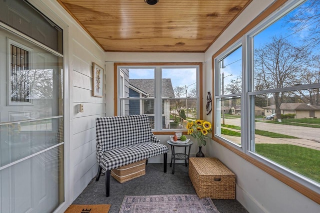 sunroom with plenty of natural light, carpet floors, and wood ceiling
