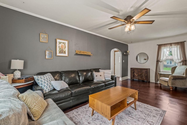 living area with crown molding, a ceiling fan, baseboards, arched walkways, and wood finished floors