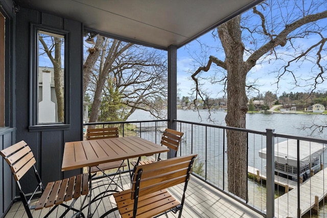 balcony featuring outdoor dining area and a water view