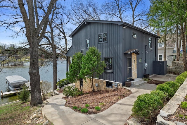 view of front of property featuring a dock and a water view