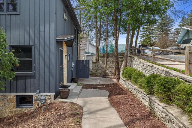 view of side of home with fence and board and batten siding