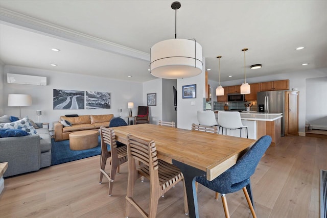 dining area featuring ornamental molding, light wood-style floors, recessed lighting, and a wall unit AC