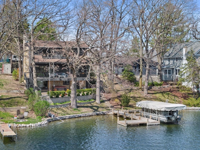 view of dock featuring stairs, a water view, and boat lift