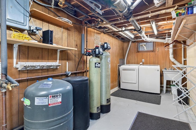 laundry area with a sink, independent washer and dryer, electric panel, laundry area, and wooden walls