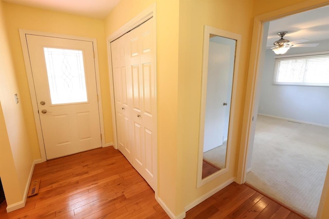 entryway featuring ceiling fan, light wood-type flooring, and baseboards