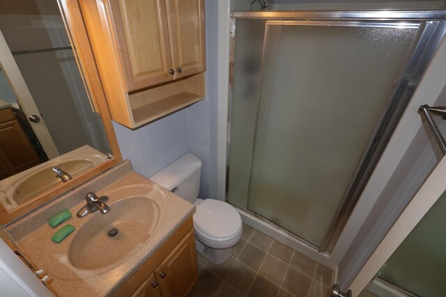 full bathroom with a stall shower, toilet, and vanity