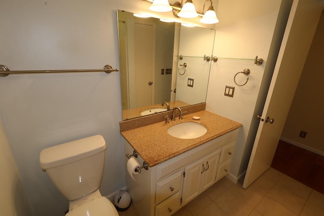 half bath featuring tile patterned floors, vanity, and toilet