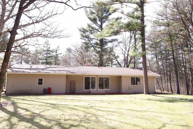 rear view of property with a lawn and a chimney