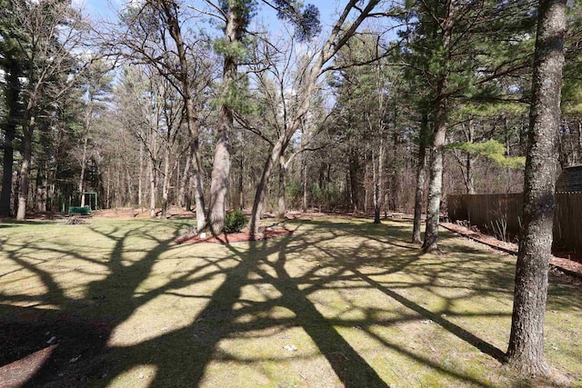 view of yard with fence and a view of trees
