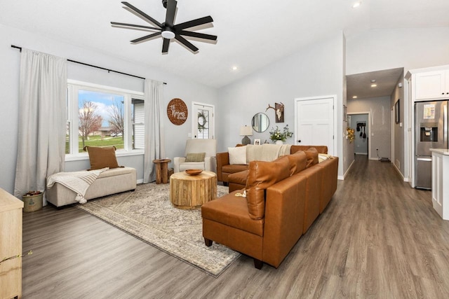 living area with baseboards, light wood-type flooring, ceiling fan, and high vaulted ceiling