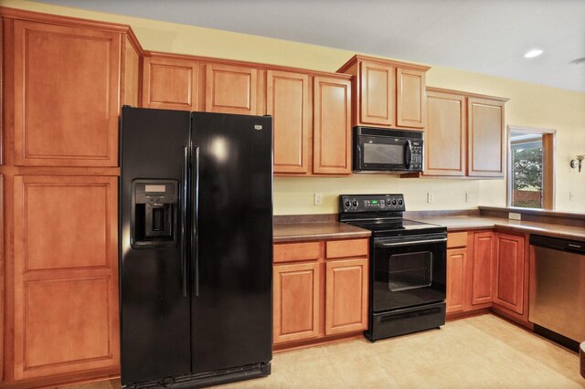 kitchen featuring black appliances, dark countertops, and light floors