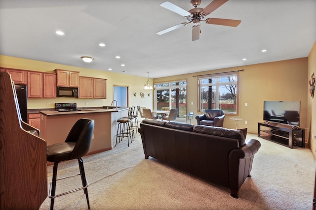 living area with light colored carpet, ceiling fan, and recessed lighting