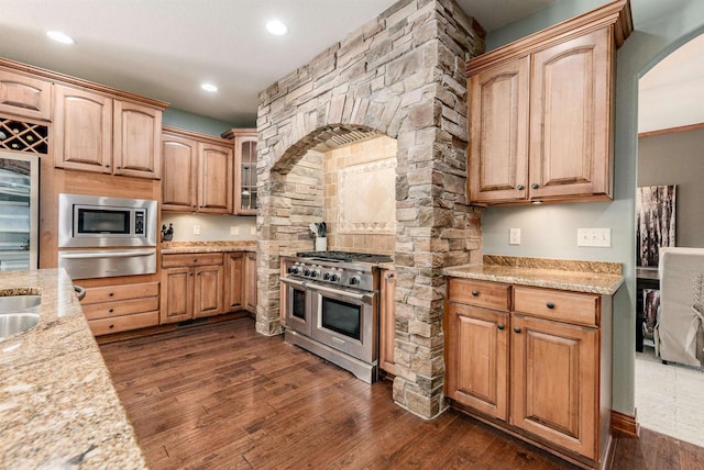 kitchen featuring dark wood-style floors, wine cooler, a warming drawer, arched walkways, and appliances with stainless steel finishes