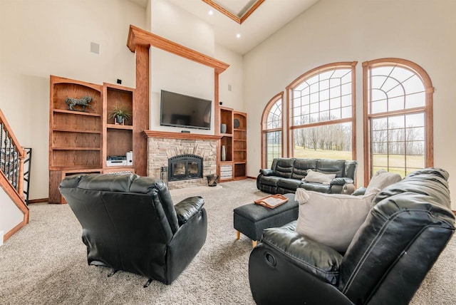 living area featuring a fireplace, a towering ceiling, carpet, and stairs