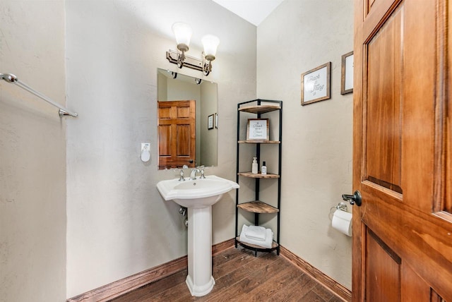 bathroom featuring a sink, wood finished floors, and baseboards