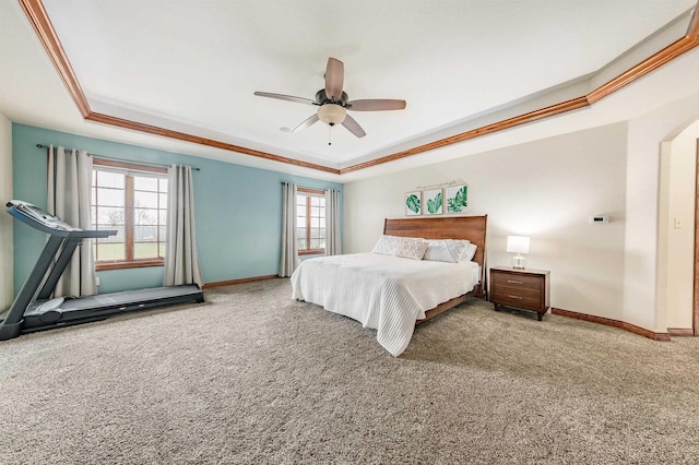 bedroom with baseboards, ornamental molding, carpet flooring, and a tray ceiling