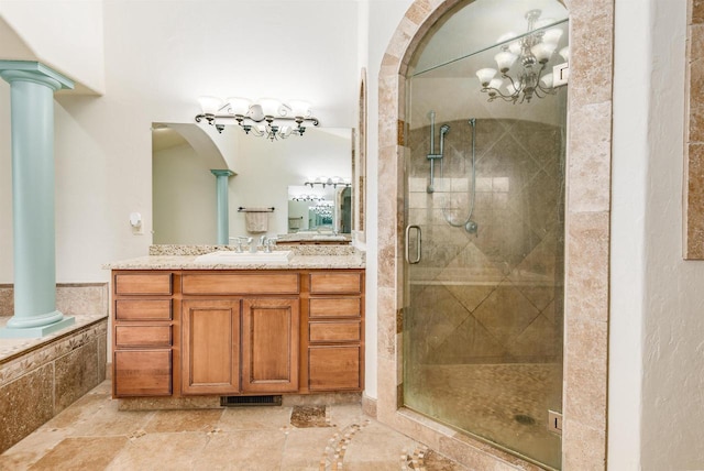 bathroom with visible vents, a stall shower, ornate columns, vanity, and a notable chandelier