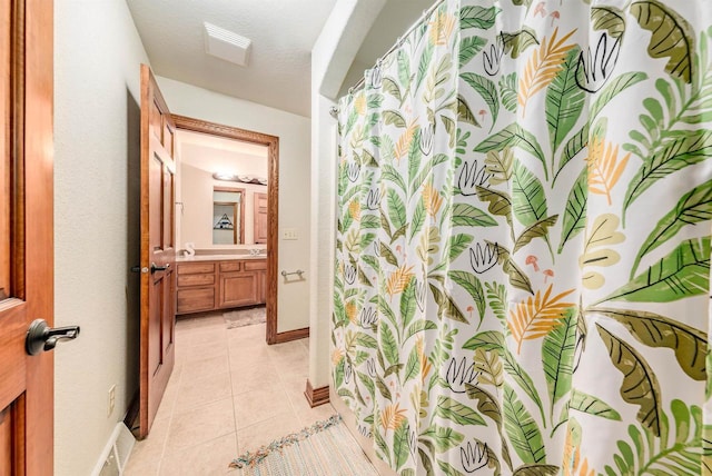 bathroom featuring vanity, curtained shower, visible vents, baseboards, and tile patterned flooring