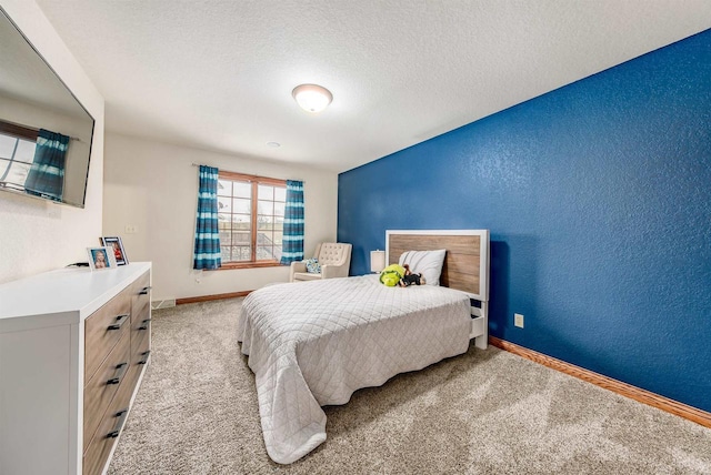 carpeted bedroom featuring a textured ceiling, a textured wall, and baseboards