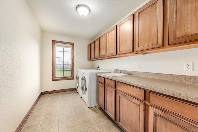 laundry room with separate washer and dryer, light tile patterned floors, cabinet space, a sink, and baseboards