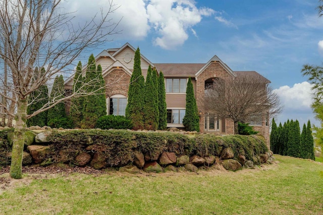view of front of property featuring a front yard and brick siding