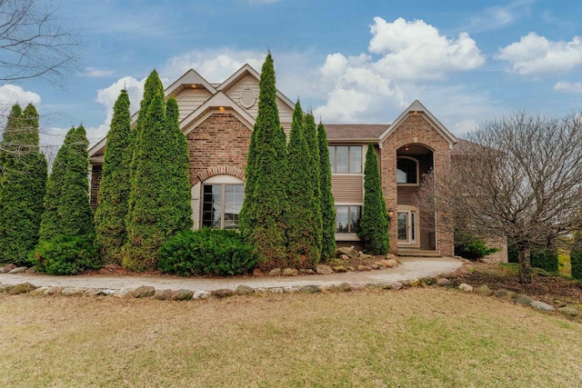 traditional-style house with brick siding and a front yard