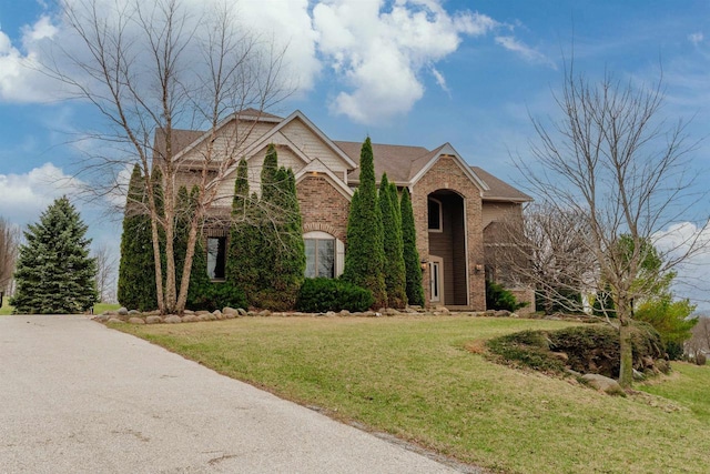 traditional-style house with a front lawn and brick siding
