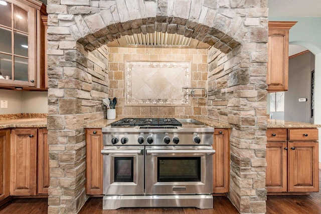 kitchen with dark wood finished floors, light stone countertops, and double oven range