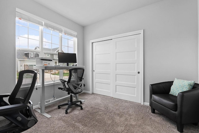 carpeted home office featuring baseboards