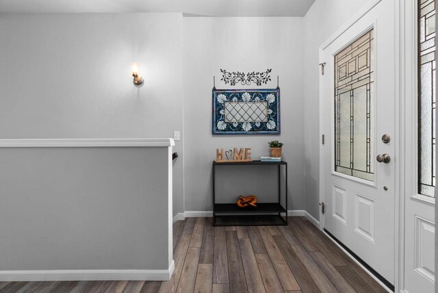 foyer featuring baseboards and wood finished floors