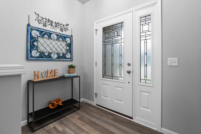 entrance foyer featuring baseboards and dark wood finished floors